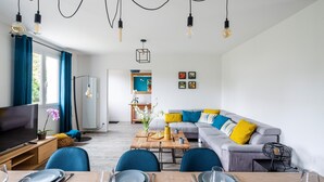 A modern living room with a TV, sofa, dining table, and chairs. - 4 bedroom lovely home in Cancale (Cancale)