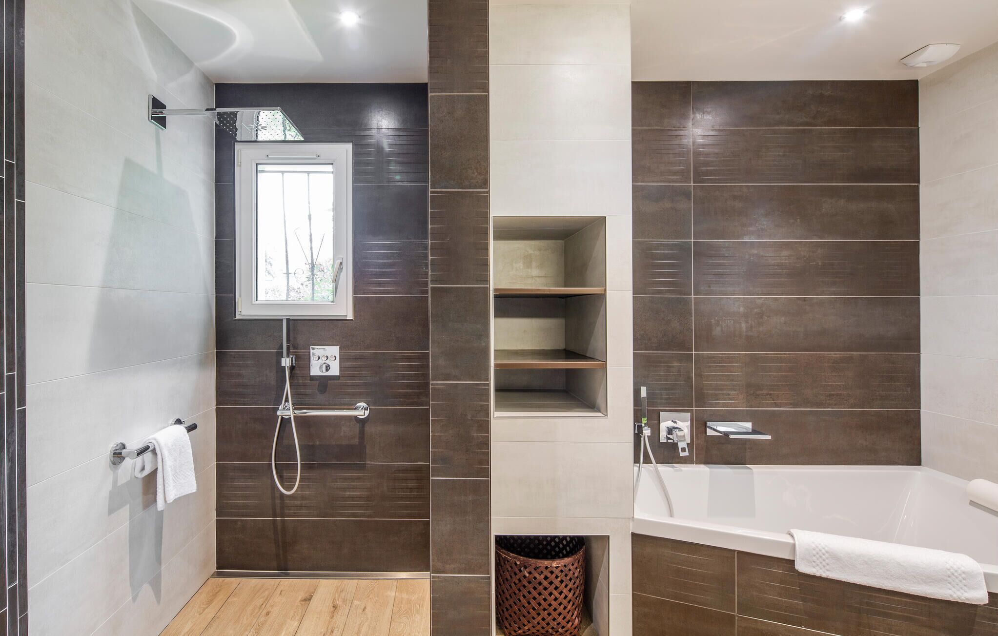 A modern bathroom with a shower, a bathtub, and a vanity with shelves.