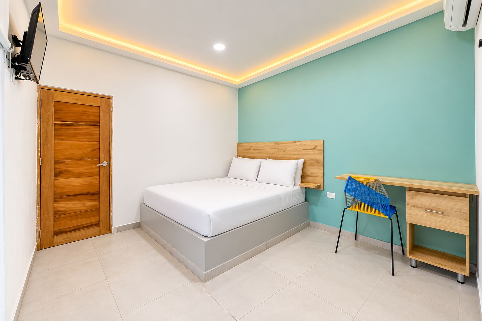 Un dormitorio con cama, escritorio y silla.