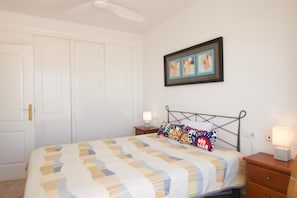 A bedroom with a bed, nightstands, a ceiling fan, a door, and a framed picture on the wall. - Villa Noma with Sea View, Pool, Garden & Wi-Fi (El Campello)