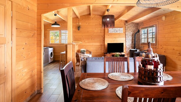 A wooden interior with a dining table, chairs, a TV, and a fireplace. - Rural House with Private Pool near Dehesa Montenmedio – Sunshine Tour, Vejer (Vejer de la frontera)