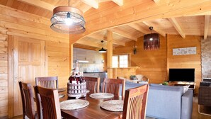 A wooden interior with a dining table, chairs, a sofa, and a TV. - Rural House with Private Pool near Dehesa Montenmedio – Sunshine Tour, Vejer (Vejer de la frontera)