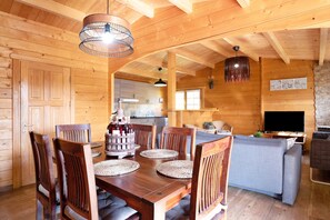 Un intérieur en bois comprenant une table à manger, des chaises, un canapé et un téléviseur.