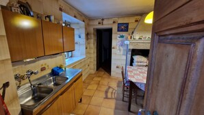 A kitchen with wooden cabinets, a sink, and a tiled floor.