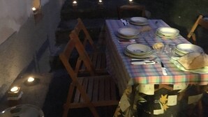 A dining table set with plates, glasses, and cutlery, surrounded by chairs.
