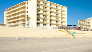 A multi-story hotel with balconies, a beach view, and a sign for Fantasy Island Resort.