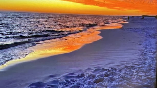 Une plage au coucher du soleil, avec les vagues de l’océan.