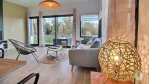 A modern living room with a sofa, a chair, a table, and a large window.