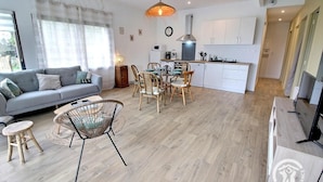 A modern apartment with a living room, dining area, and kitchen.