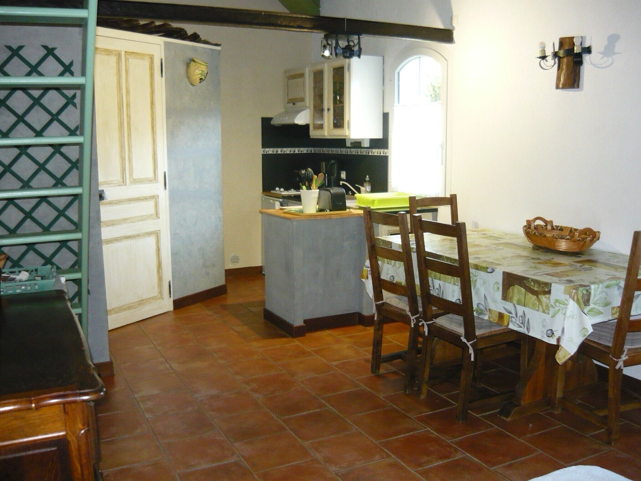 Una cuina amb taula de dinar, cadires i una petita illa.