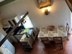Uma cozinha com mesa, cadeiras e janela.