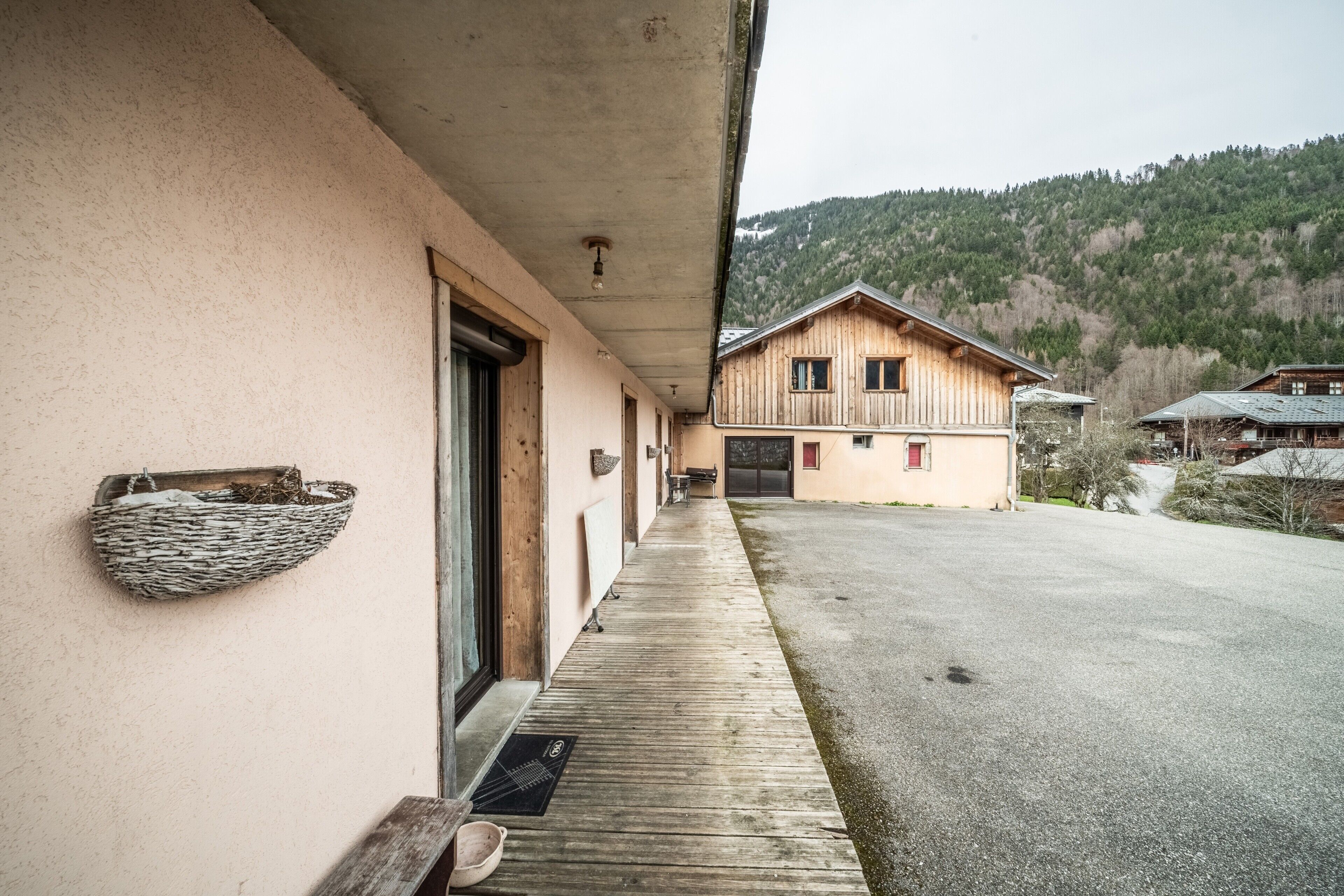 Un bâtiment à l’extérieur en bois, doté d’un porche abrité et surplombant un paysage montagneux.