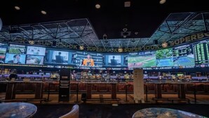 A bar area with multiple screens displaying sports events, a bar counter, and seating arrangements.