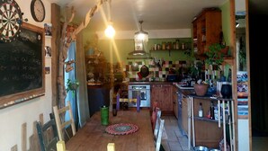 A kitchen with a wooden table, a chandelier, and a chalkboard with writing.