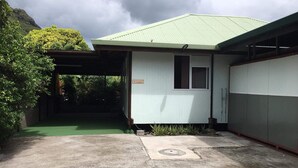 A small, single-story building with a green roof and a covered entrance.