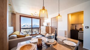 Una cocina moderna con comedor, ventanas amplias con vistas a la montaña y una zona de estar acogedora.