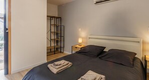 Relax in a serene bedroom with a large bed, bedside table, and ample storage.