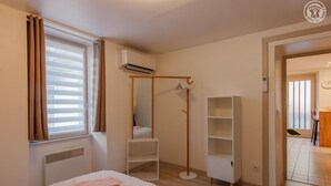 A bedroom with a bed, a wardrobe, a mirror, and a window with blinds. - Deja Viuz - Chindrieux (CHINDRIEUX)