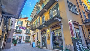 A street with a yellow building featuring a shop with mannequins and a sign that reads 'EMPOTI'. - La Casa di Maddalena Stresa Centre: 2 Bed, 2 Bath, Balconies (Stresa)