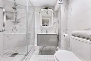 Appartement | Badkamer | Een douche, een haardroger, handdoeken