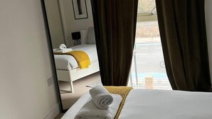 A hotel room with a bed, a large mirror, and a view of the outside. - Stunning 1-bed Apartment in London (London)