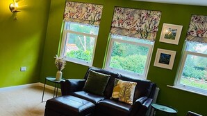 A living room with a sectional sofa, a small table, and a decorative ceiling light. - Central Beverley 4-bedroom Townhouse (Beverley)