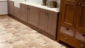 A kitchen with light brown cabinets, a white countertop, and a wooden cabinet with wicker baskets. - Central Beverley 4-bedroom Townhouse (Beverley)