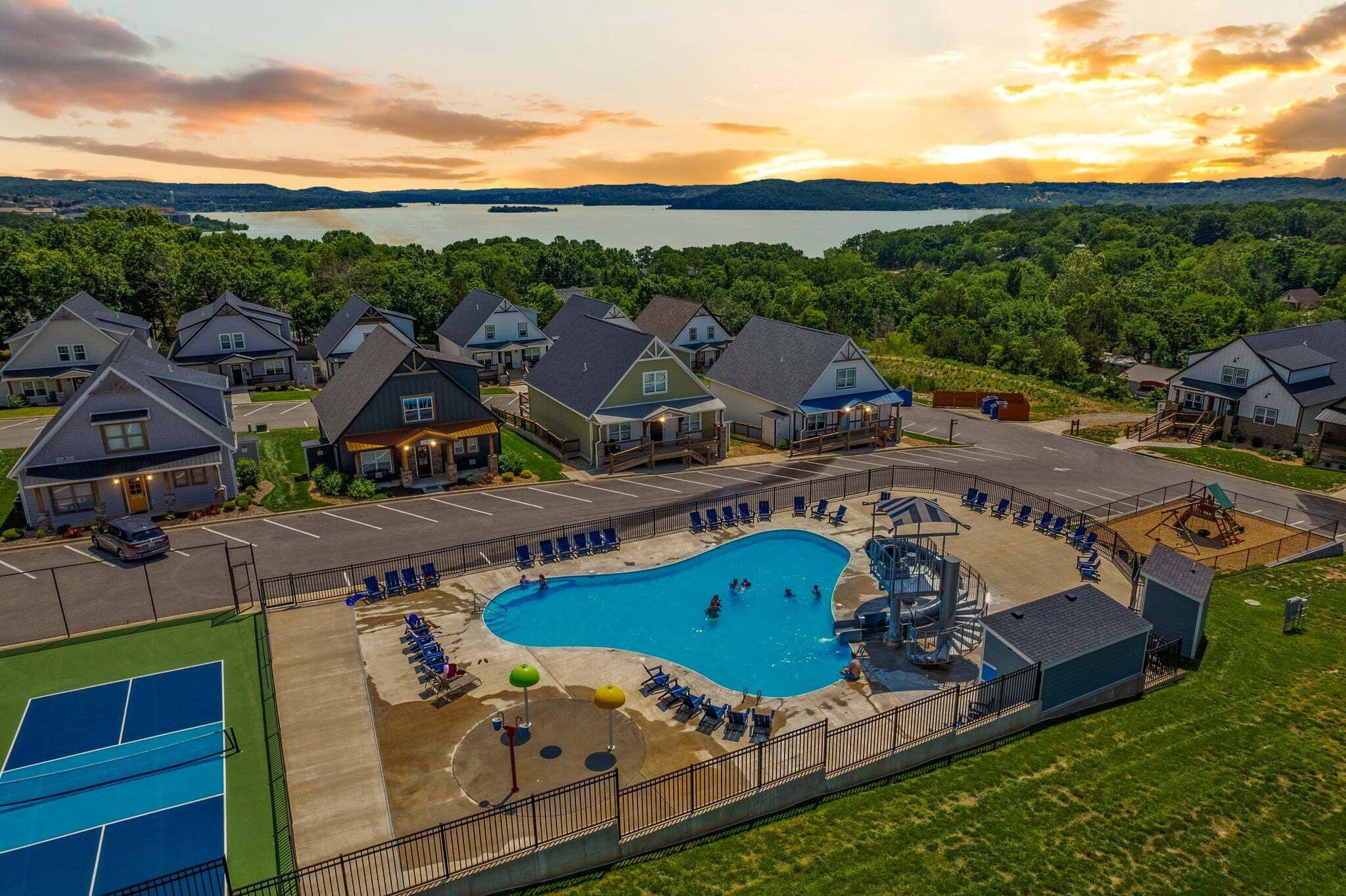 A residential area with houses, a swimming pool, and a tennis court.