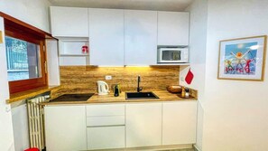 Réfrigérateur, four à micro-ondes, surface de cuisson, cafetière-théière