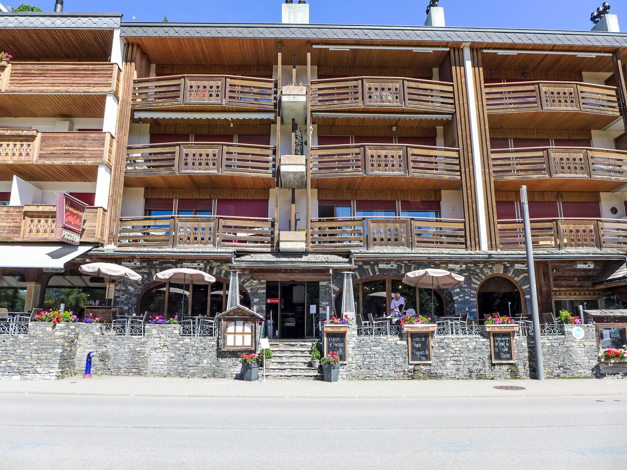 Un edificio de varios pisos con balcones de madera y fachada de piedra.