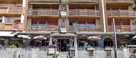 Un edificio de varios pisos con balcones de madera y fachada de piedra.