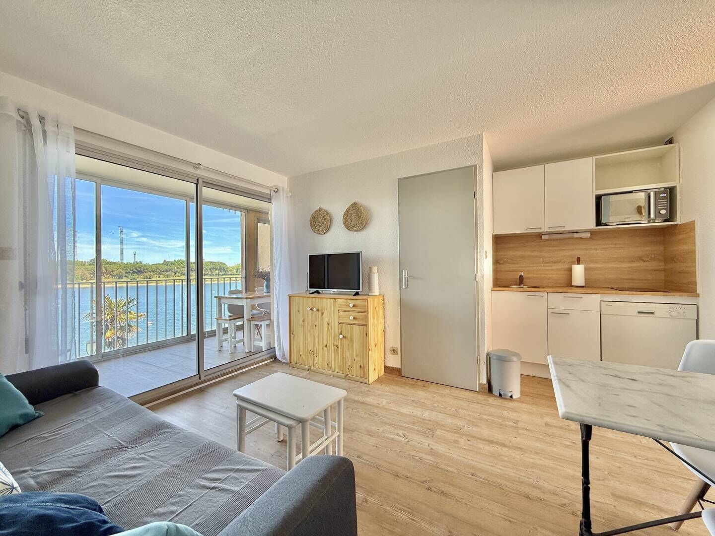 Eine moderne Wohnung mit Balkon, Essbereich, Küche und Wohnzimmer.