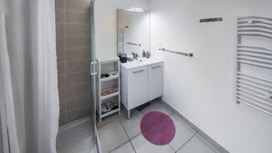 A bathroom with a shower, a sink with toiletries, a mirror, and a towel rack. - Pet friendly home in Agde with WiFi (Agde)