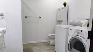 A laundry room with a washing machine, a dryer, and a toilet. - The Beautiful Nubia - 5 Mins Drive to the Calypso Waterpark.  (Limoges)