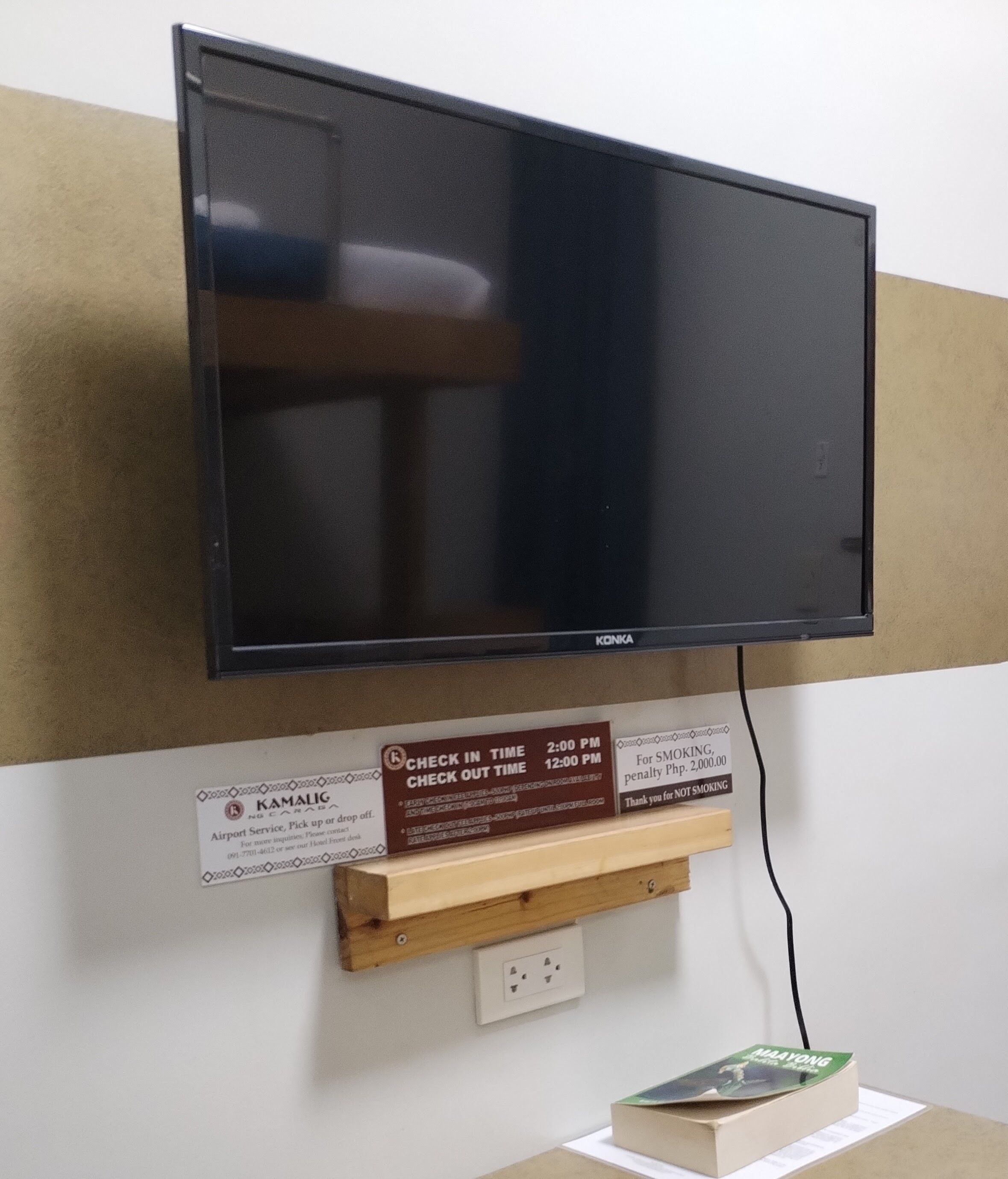 Un televisor montado en la pared con un cartel debajo.