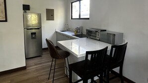 A compact kitchen with a refrigerator, toaster, and sink.