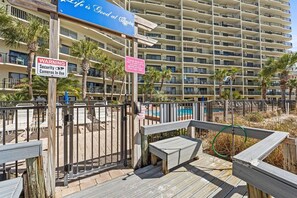 Un hotel con un cartel de advertencia de seguridad, una zona de piscina y una terraza de madera.