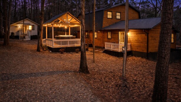 Eine Hütte mit Veranda, Whirlpool und einer Terrasse.