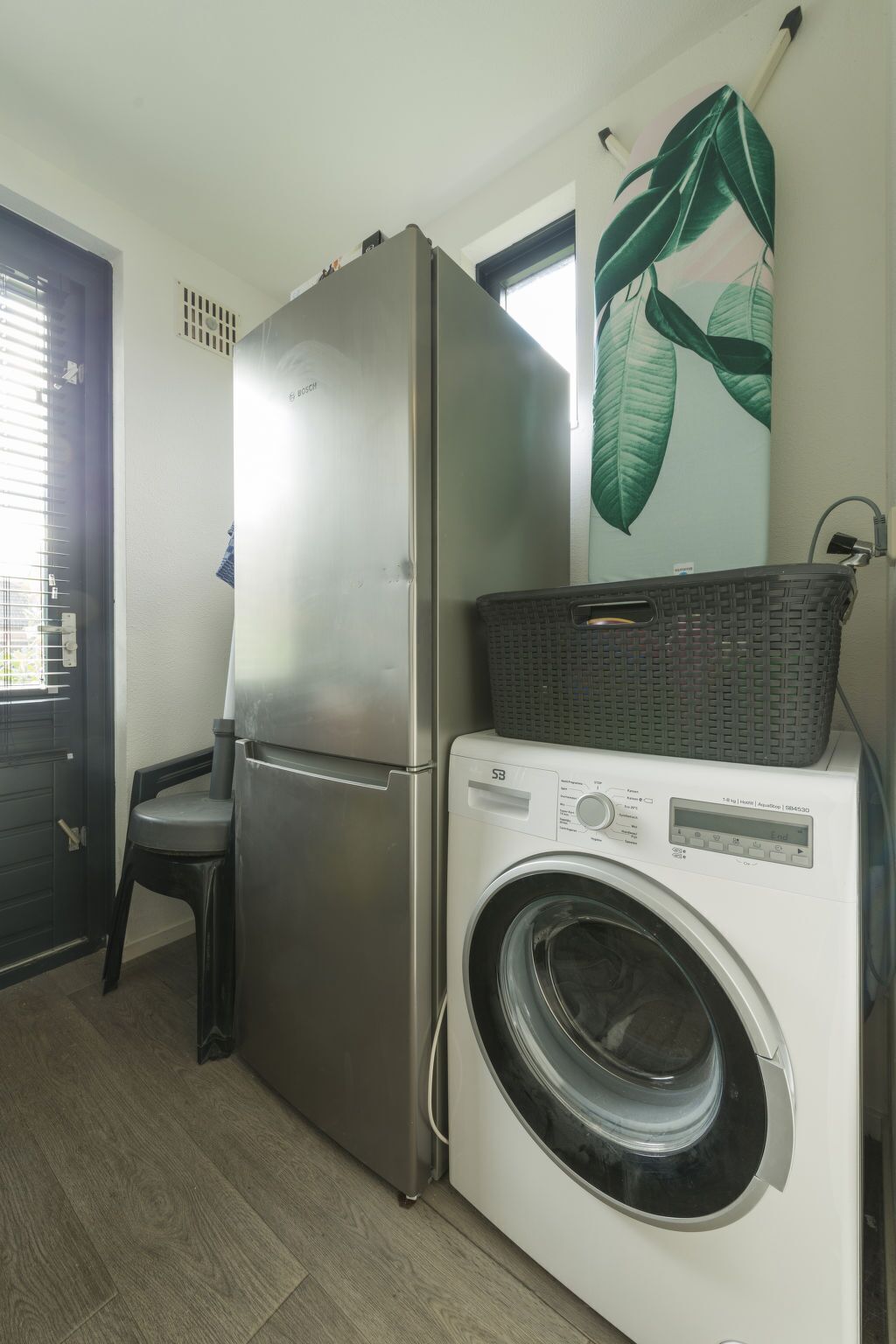 A compact laundry area with a washing machine and a refrigerator.