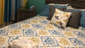 Ein Schlafzimmer mit einem Bett, einem Nachttisch, einer Klimaanlage und einem gerahmten Bild an der Wand.