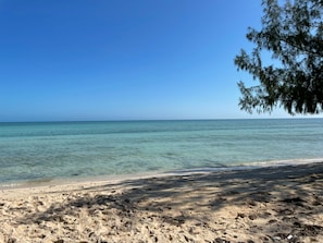 A beach with clear turquoise water and sandy shore. - Three A's Getaway, 15 min walk to sun, sand and sea! (Nassau)
