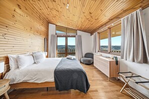 A bedroom with a wooden ceiling, a bed, a desk, and a view of the outdoors. - Chalet Kanimbla - Breathtaking 360 views on the top of Mount Kanimbla (Kanimbla)