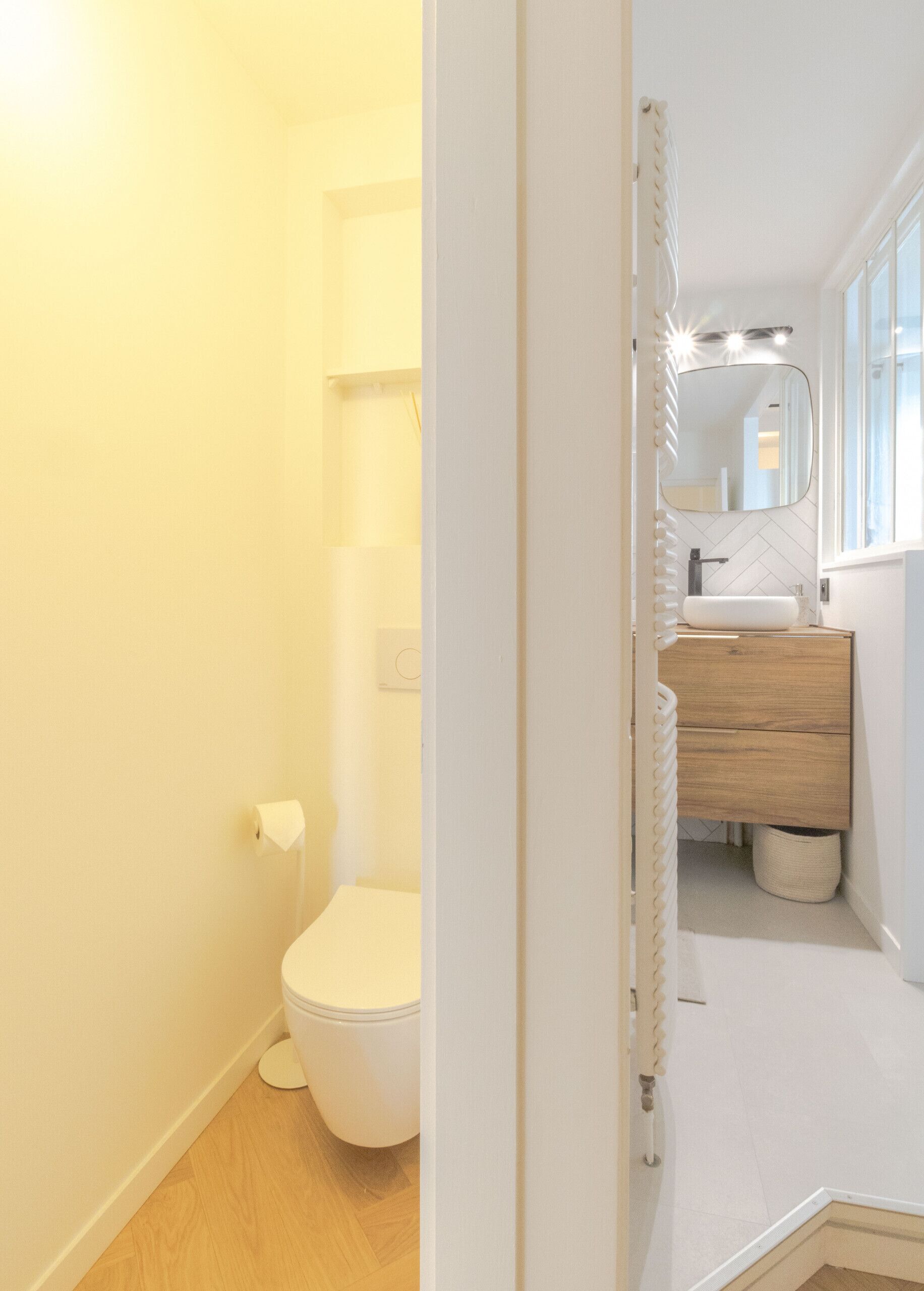 Une petite salle de bain comprenant des toilettes, un lavabo avec un miroir et un espace douche.