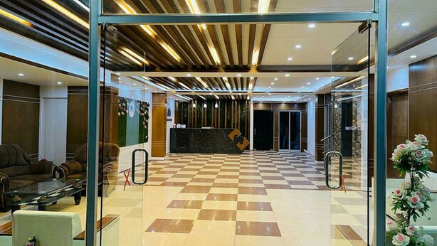 A lobby with a checkered floor, a reception desk, and a staircase leading to an upper level. - Reem Resort (Cox's Bazar)