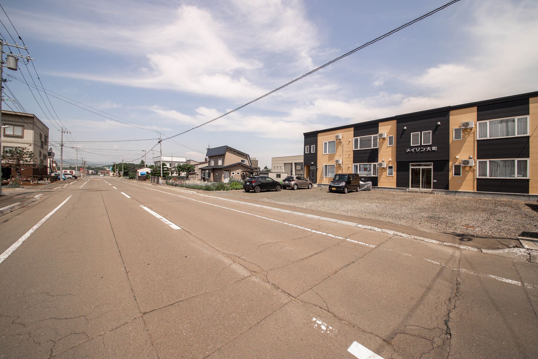 A street with buildings, including a two-story structure with a sign reading "Mei-Izon".