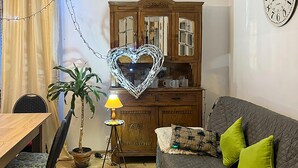 A cozy living room with a wooden cabinet, a dining table, a lamp, a sofa with cushions, and a potted plant. - Stunning home in Rybical with WiFi (Rybical)