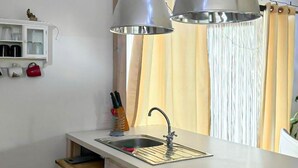 A compact kitchen with a sink, a cabinet with glass doors, and a window with curtains. - Stunning home in Rybical with WiFi (Rybical)