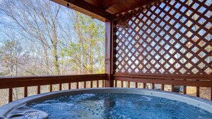 A hot tub with a wooden deck and lattice structure, surrounded by trees. - Pool! View~Air Hockey~Fire Pit~Hot Tub~SemiSeclude (Sevierville)