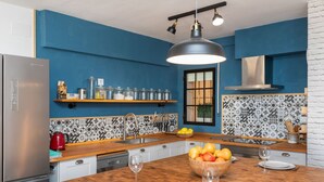 A modern kitchen with blue walls, a wooden island, and a stainless steel refrigerator. - Pescadors by Interhome (Alcanar)