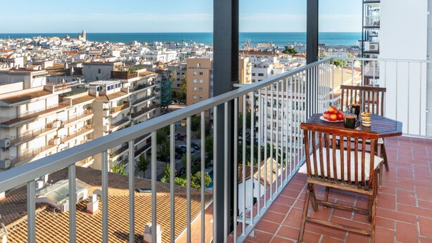 A balcony with a table and chairs, overlooking a cityscape and the sea. - Cortijo Barques by Interhome (Sitges)